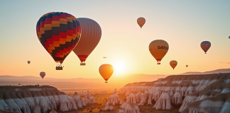 Montgolfières colorées survolant les formations rocheuses de Cappadoce au lever du soleil