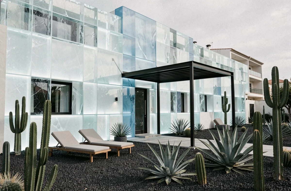 Façade avant-gardiste du Kube Hôtel Saint-Tropez avec ses panneaux translucides et son jardin minimaliste en gravier noir